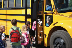 Des enfants qui embarquent dans un autobus scolaire