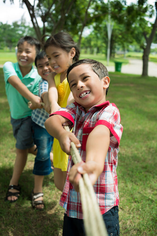 4 young children pulling on a rope